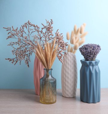 Masanın üzerinde kurumuş çiçekler olan vazolar..