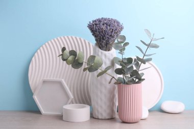 Alçı geometrik şekilli mavi bir zemin üzerinde lavanta ve okaliptüs vazoları