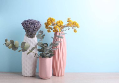 Farklı kurumuş çiçekli vazolar, mavi arkaplan