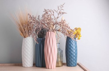 Masanın üzerinde kurumuş çiçekler olan vazolar.