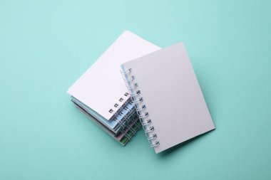 Nane yeşili arkaplan üzerine beyaz boş spiral dizüstü bilgisayarlar yığını