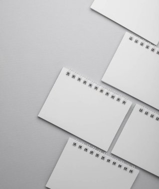 Gri arkaplan üzerine beyaz, boş, sarmal defterler. Boşluğu kopyala