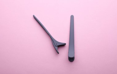 Pembe arka planda plastik mandallar.