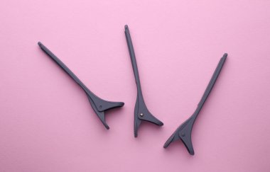 Pembe arka planda plastik mandallar.