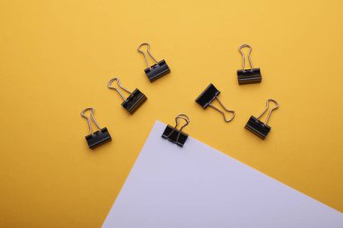 Sarı zemin üzerinde klasörler olan beyaz kağıt.