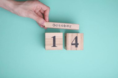 Nane yeşili arka planda 14 Ekim tarihli ahşap blok takvimi