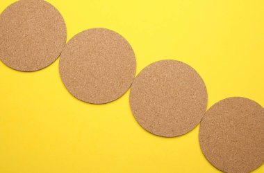 Sarı arka planda içecekler için mantar altlığı