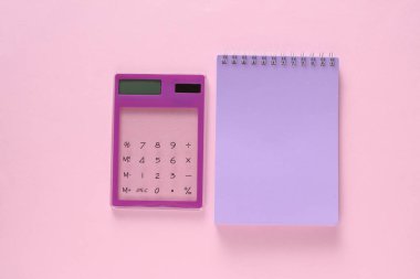 Pembe arka planda saydam hesap makinesi ve natebook. İş konsepti. Üst görünüm