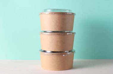 Masada plastik kapaklı karton yuvarlak yiyecek kutuları, turkuaz arka plan