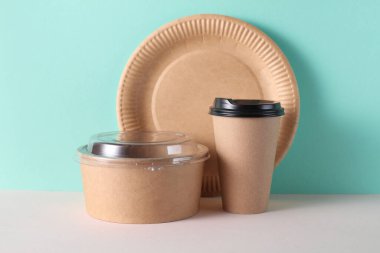 Nane yeşili arka planda karton yemek konteynırları. Kutu, kupa ve tabak