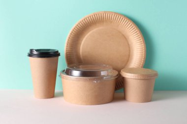 Nane yeşili arka planda karton yemek konteynırları. Kutu, kupa ve tabak