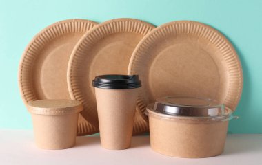 Karton paket servis kutuları ve nane yeşili arka planda tabaklar.