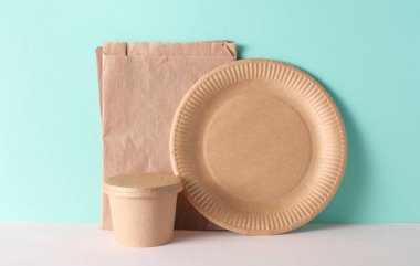 Karton paket servis kutuları ve nane yeşili arka planda tabaklar.