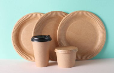 Karton paket servis kutuları ve nane yeşili arka planda tabaklar.