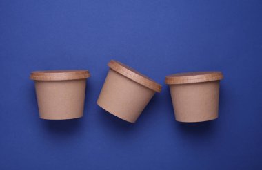 Mavi arka planda yiyecek kutularının etrafında eko karton. Üst görünüm