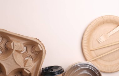 Bej arka planda birçok tek kullanımlık yemek takımı var. Üst Manzara. Boşluğu kopyala