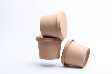 Beyaz arka planda yüzen yiyecek kutularının etrafında eko karton