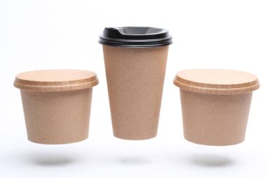 Çevredeki yiyecek kutuları ve beyaz arka planda yüzen eko sıcak içecek bardağı.