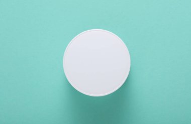 Nane yeşili arka planda beyaz krema kavanozu. Üst görünüm