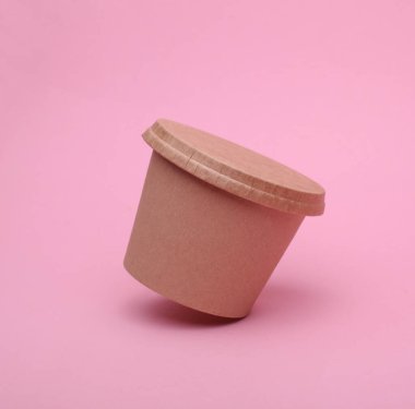 Eko karton, pembe arka planda yüzen yiyecek kutusu.