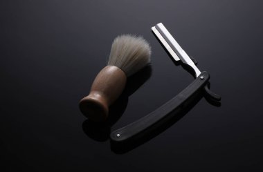 Tıraş fırçası düz bir jilet ile siyah bir arka planda yansıması ile