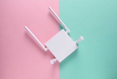 Pembe arka planda modern dört antenli Wi-Fi yönlendirici. Üst görünüm