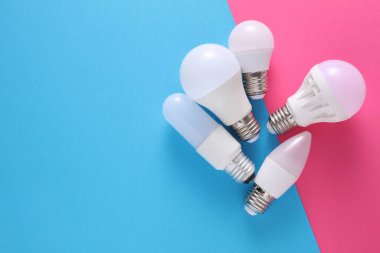 Mavi pembe arkaplanda farklı şekillerde LED ampuller