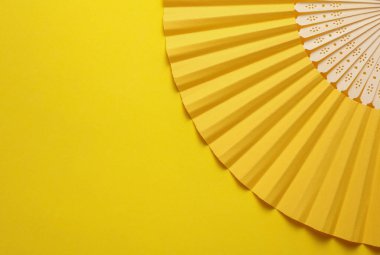 Sarı arka planda geleneksel sarı Asyalı el vantilatörü