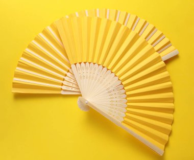 Sarı arka planda geleneksel Asyalı sarı el yelpazesi