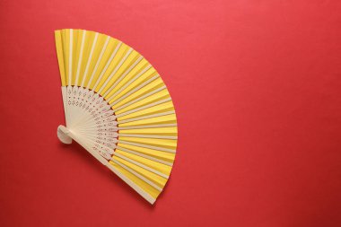 Kırmızı arka planda geleneksel sarı Asyalı el vantilatörü