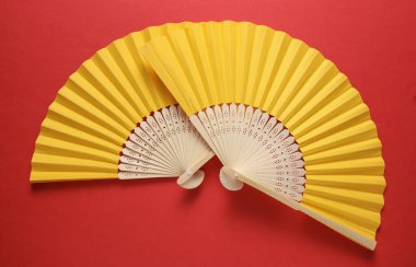 Kırmızı arka planda geleneksel sarı Asyalı el vantilatörü