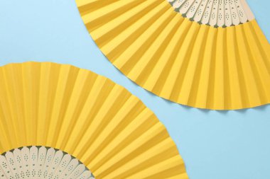 Geleneksel Asyalı sarı el hayranları mavi arka planda