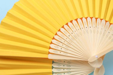 Geleneksel Asyalı sarı el hayranları mavi arka planda