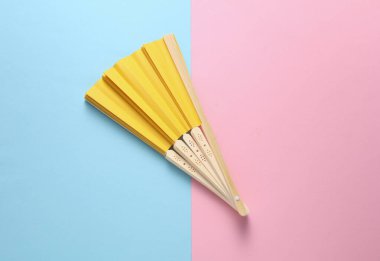 Pembe arka planda geleneksel sarı Asyalı el vantilatörü