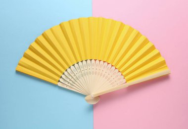 Pembe arka planda geleneksel sarı Asyalı el vantilatörü
