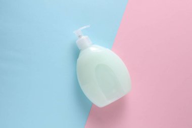 Mavi arka planda şeker kutulu sıvı sabun şişesi.