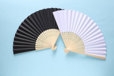 Geleneksel siyah Asyalı el hayranları mavi arka planda