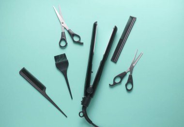 Mavi arka planda saç şekillendirme için düz saç modelleme aletleri ve aksesuarları vardı. Üst görünüm