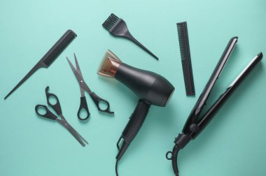 Mavi arka planda saç şekillendirme için düz saç modelleme aletleri ve aksesuarları vardı. Üst görünüm