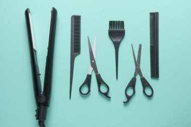 Mavi arka planda saç şekillendirme için düz saç modelleme aletleri ve aksesuarları vardı. Üst görünüm