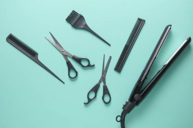 Mavi arka planda saç şekillendirme için düz saç modelleme aletleri ve aksesuarları vardı. Üst görünüm