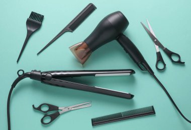 Mavi arka planda saç şekillendirme için düz saç modelleme aletleri ve aksesuarları vardı. Üst görünüm