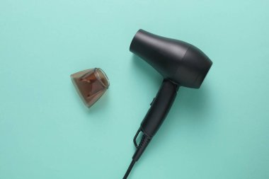 Mavi arka planda modern siyah saç kurutma makinesi