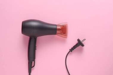 Pembe arka planda kablo ile siyah saç kurutma makinesi