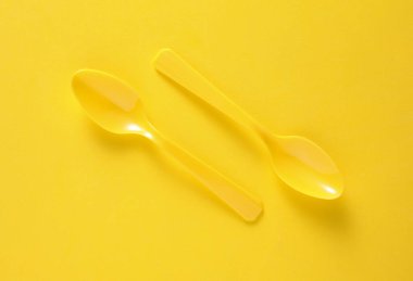 Sarı arkaplanda plastik kaşık seti
