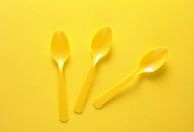 Sarı arkaplanda plastik kaşık seti