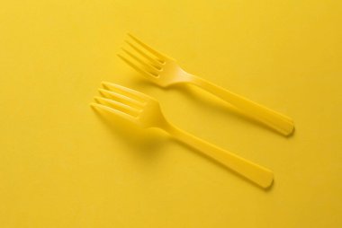 Sarı zemin üzerinde plastik çatal seti