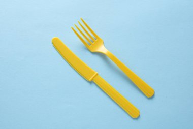 Sarı Plastik çatal ve bıçak mavi arka planda