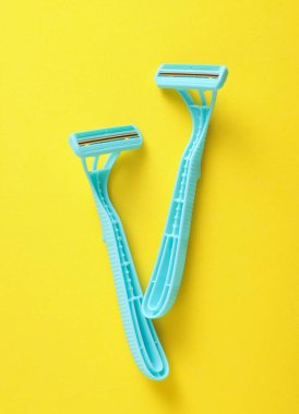 Sarı arka planda tek kullanımlık mavi jiletler