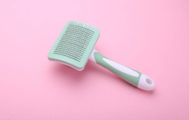 Pembe arka planda evcil hayvan saç fırçası